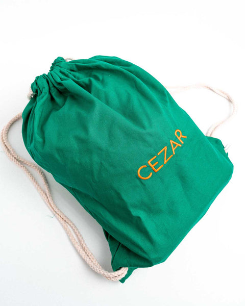 Groene turnzak met oranje letters geborduurd