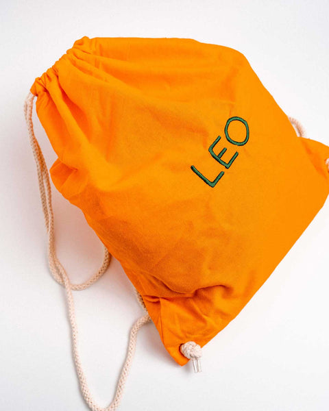 Oranje turnzak met groene letters geborduurd
