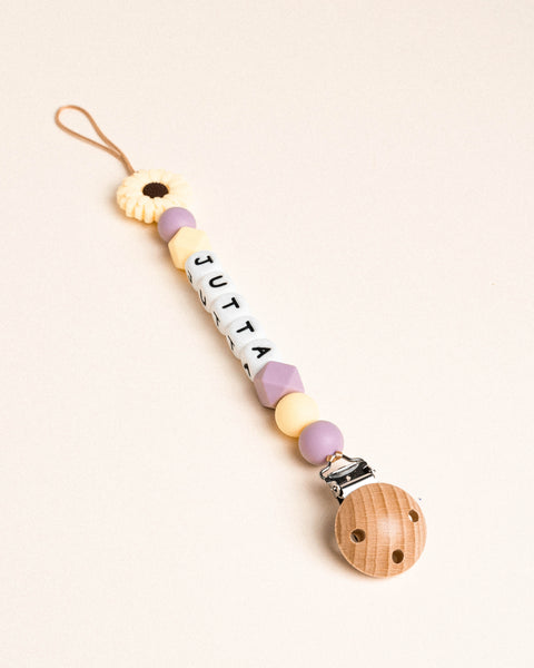 Fopspeen ketting met zonnebloem en pastel gele en paarse kralen.