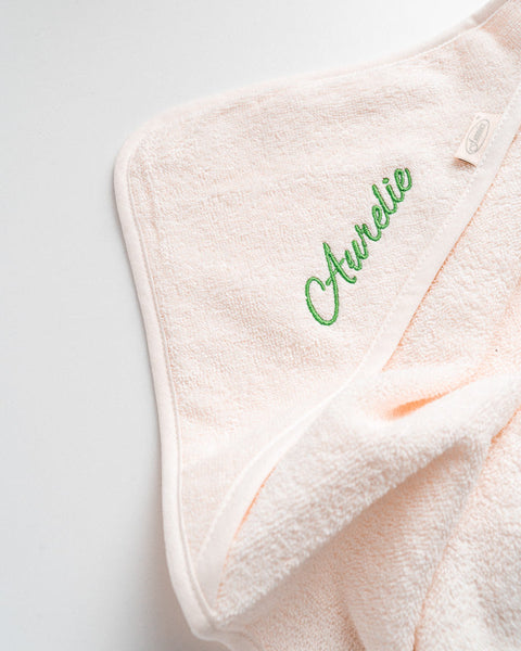 witte badcape voor kinderen geborduurd met de naam aurelie in groene letters
