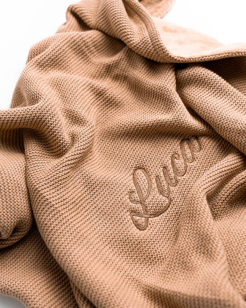 bruin geborduurd dekentje van het merk jollein met de naam Luca geborduurd in handgeschreven lettertype