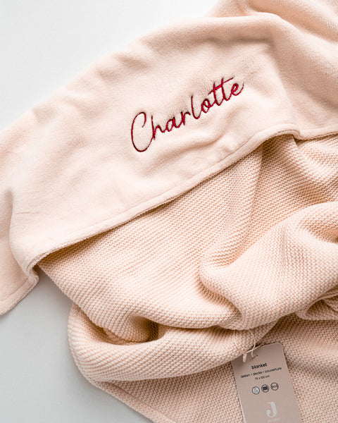 dekentje van het merk Jollein met naam geborduurd op de overslag