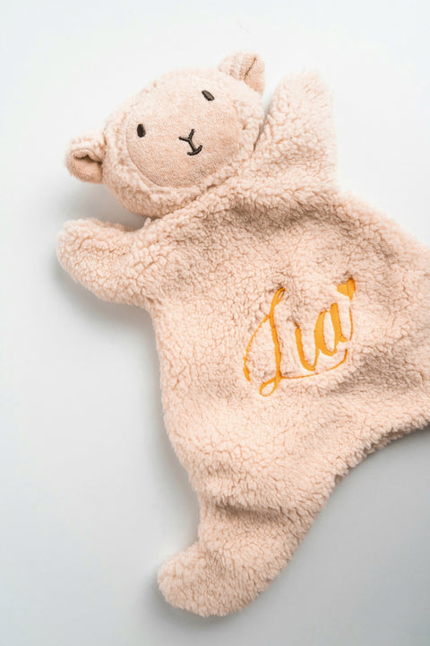 knuffeldoek in vorm van een schaap met naam geborduurd in lettertype en kleur van geboortekaartje