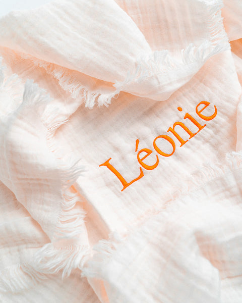 geborduur fringe dekentje van het merk jollein met de naam léonie geborduurd in oranje letters
