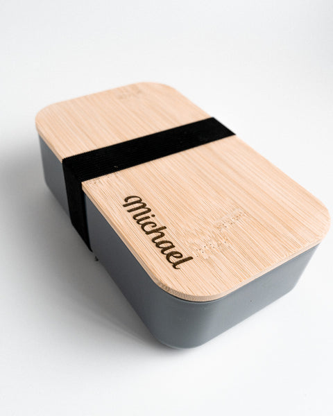 grijze lunchdoos met naam gegraveerd op houten deksel