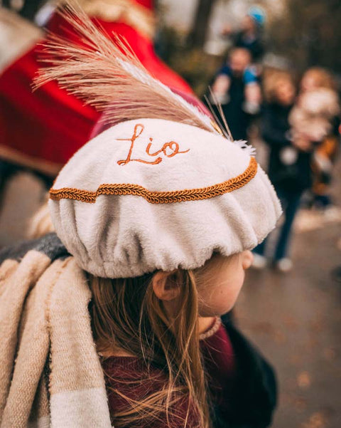 kindje die gepersonaliseerde pietenmuts draagt bij intrede van de sint