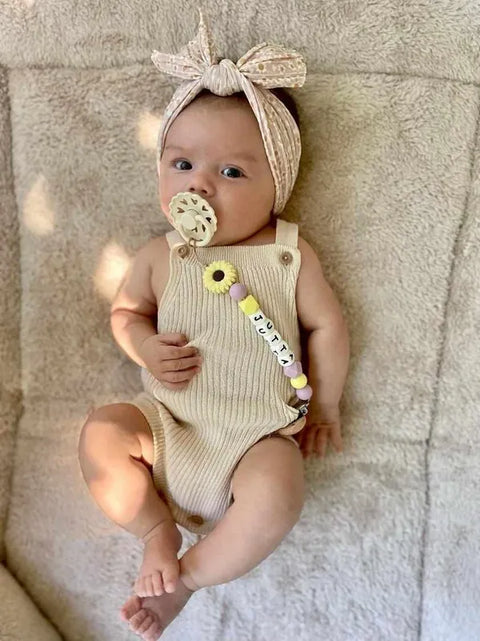 foto van schattige baby met gepersonaliseerde speenkoord